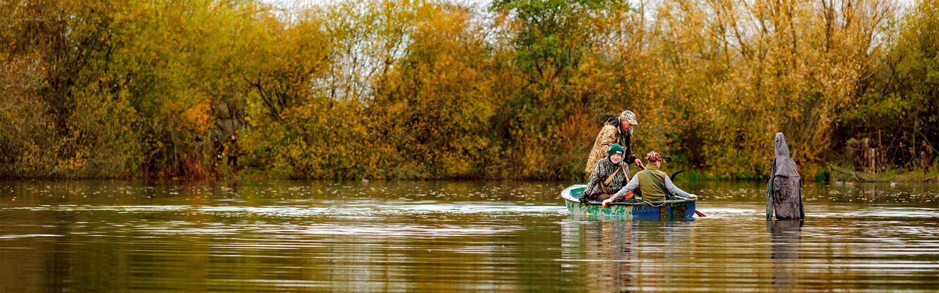 Wildfowlers in a small boat crossing water