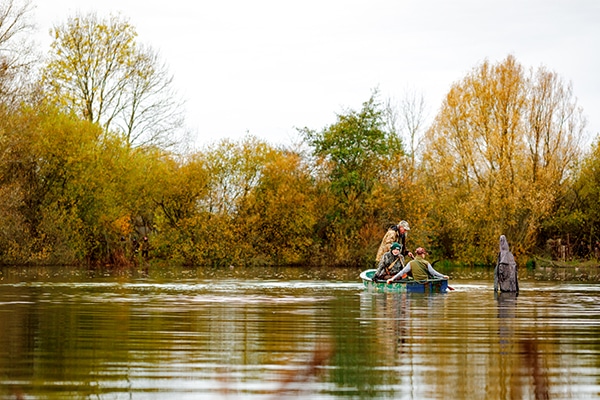 Wildfowlers in a small boat crossing water