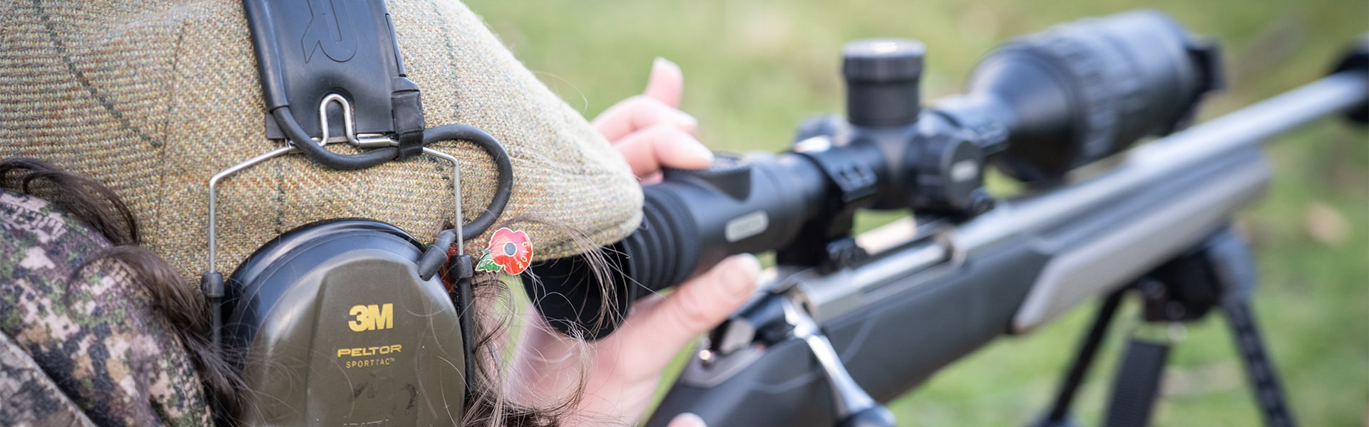 A target shooter aiming down the scope of their rifle