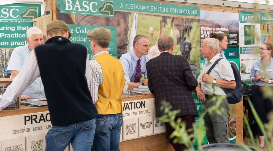 BASC staff talking to members at the Game Fair stand