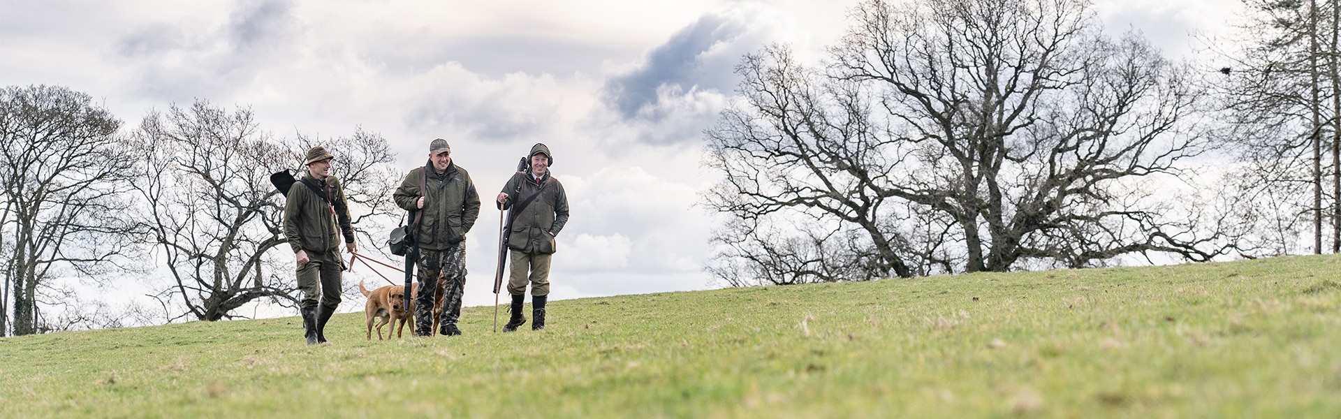 Game shooters walking in a field