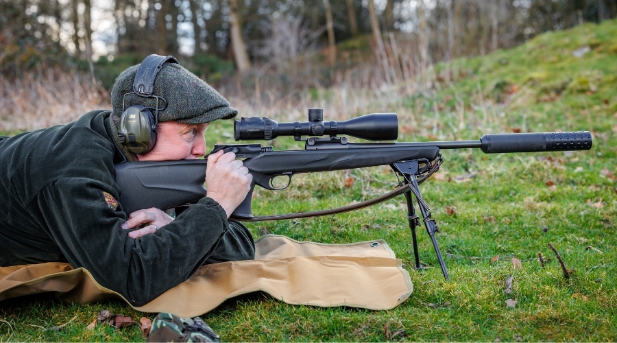 A shooter aiming down the scope of a rifle